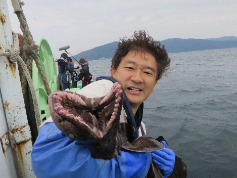 船上で深海魚を手にする講師