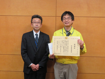 横浜税関職員と感謝状を手にする学芸員の折原